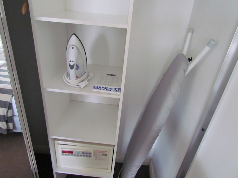 The large mirrored closet upstairs has sensible storage options, plus an iron and ironing board.