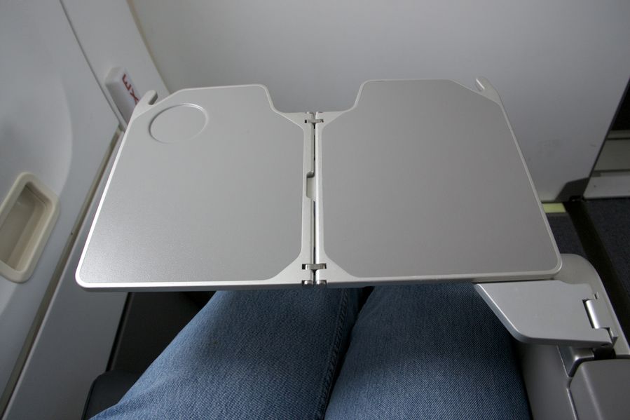 The table folds out from the armrest in row 1.