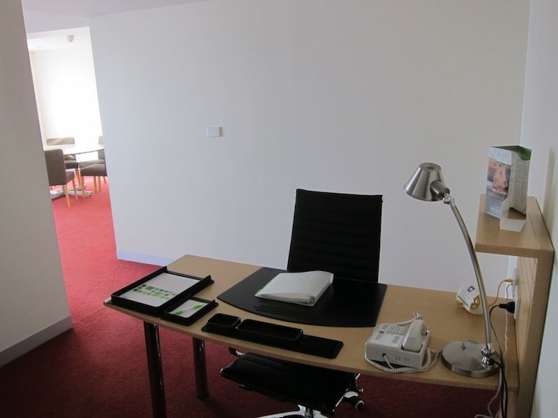 The desk in the room is large, but covered in office organisers.