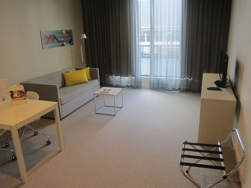 The living area is an excellent size, with big windows and bright, modern decor.