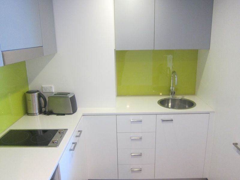 The kitchen, too, is well-sized, with bright lime accents.