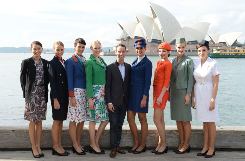 Martin Grant, flanked by Qantas cabin crew wearing uniforms spanning the decades
