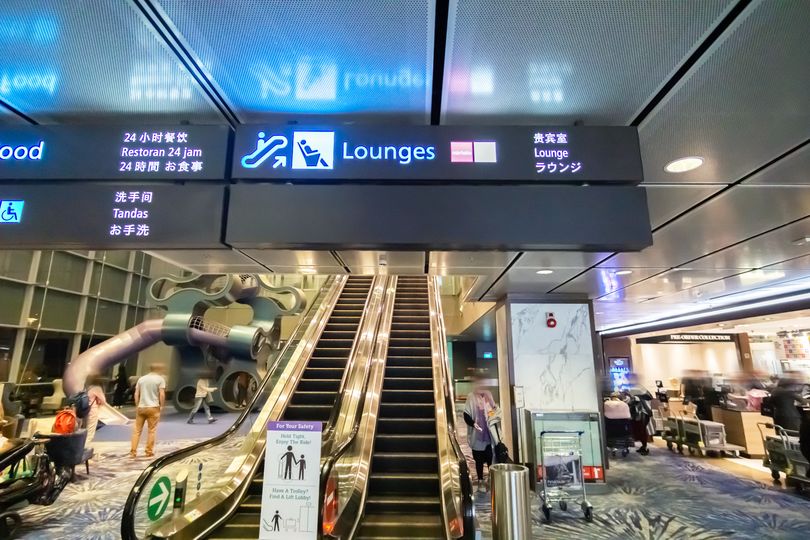 Signs for the Marhaba (red icon) and KrisFlyer Gold (white icon) lounges.