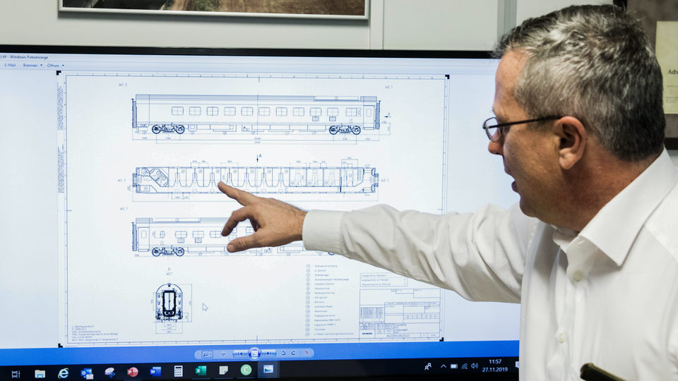 Paul Winkler inspects blueprints for a new sleeper carriage design.