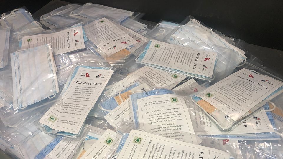 Passengers pick up a Fly Well pack before boarding the aircraft.