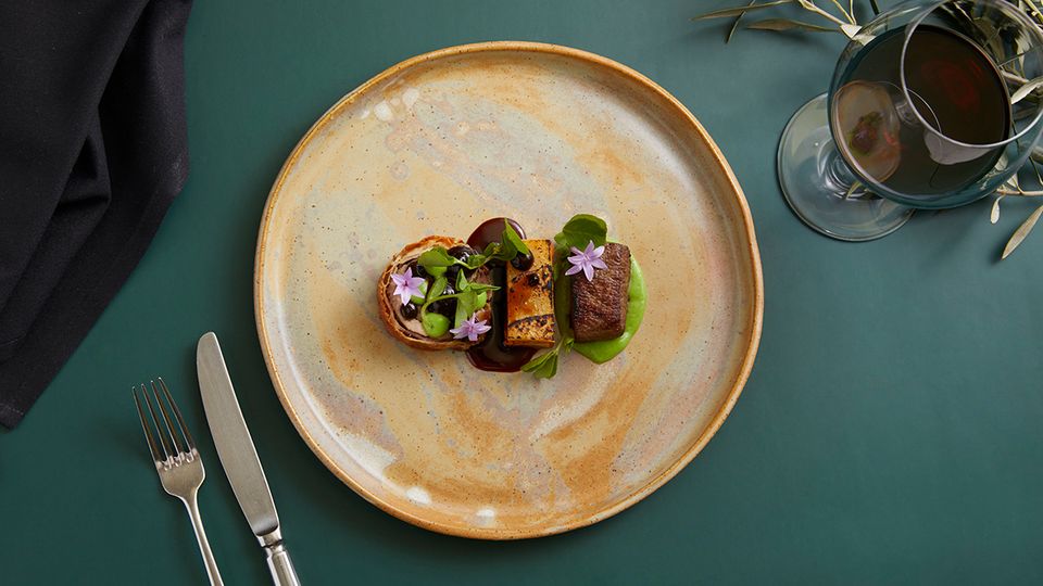 Bite into braised lamb with black garlic and a root vegetable gratin at Restaurant Botanica.
