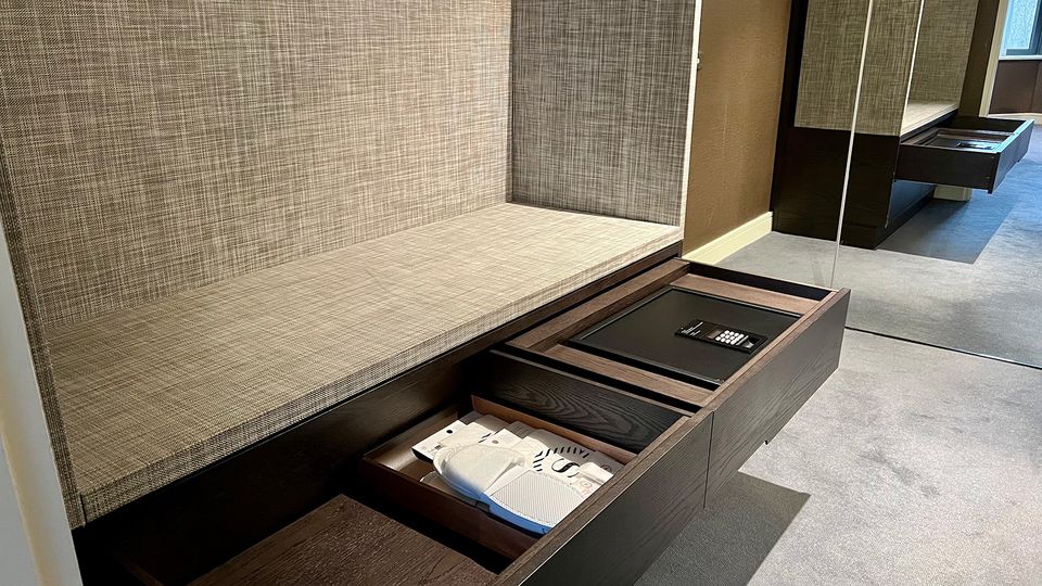 The dressing area includes ample draw and hanging space, with an iron and full-size ironing board.