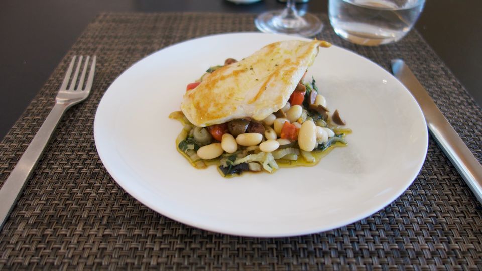 New to the Qantas First Lounge summer menu: grilled chicken breast atop a warm salsa of white beans, slow-roasted tomatoes and Kalamata olives.