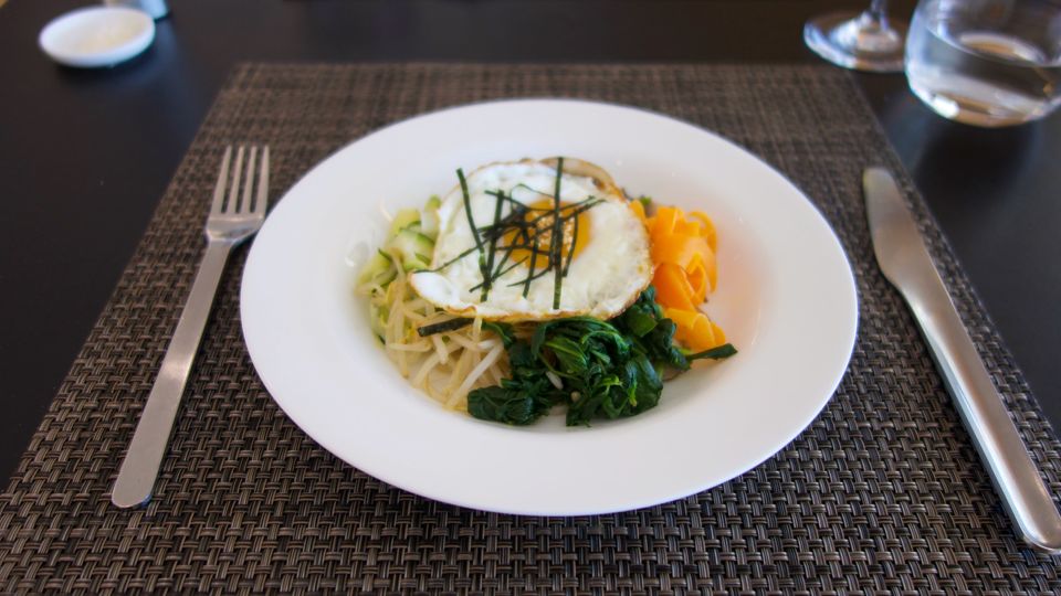 New to the Qantas First Lounge summer menu: vegetarian bibimbap with mushrooms, sprouts, pickles and spinach, topped by a fried egg.