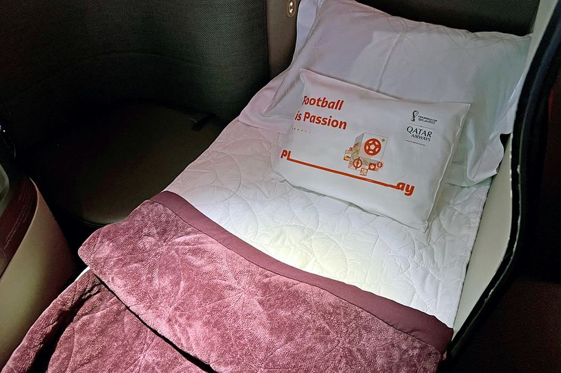 A souvenir pillow tops off the freshly-made bed.