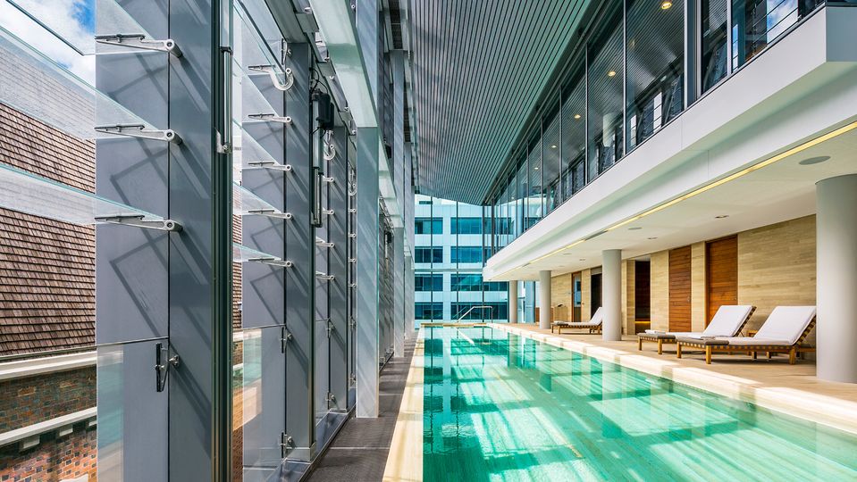 The pool is overlooked by a gymnasium with TechnoGym equipment.