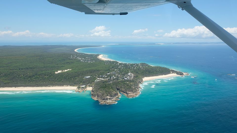 Flying alongside Point Lookout, renowned for its surfing and whale watching.