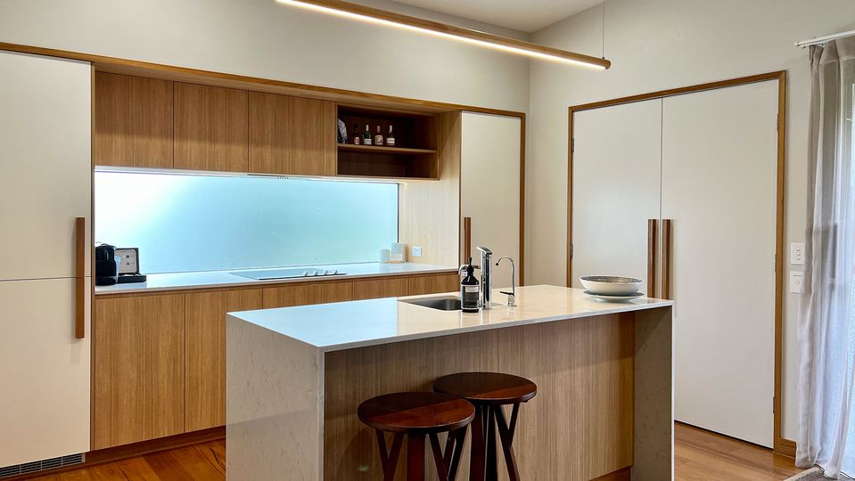 A full-size fridge is discreetly hidden behind the left cabinet.