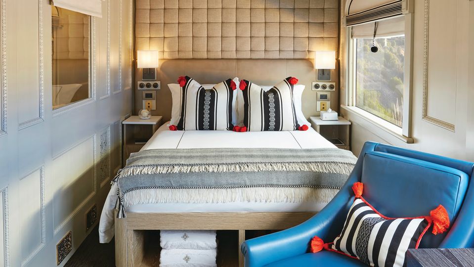 Suites feature a double bed and seating area with two chairs.