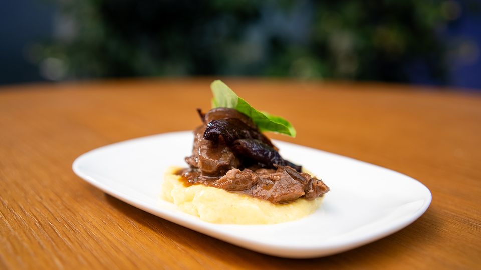 Slow cooked wild Fiordland venison with pancetta, parmesan polenta and balsamic roasted red onions