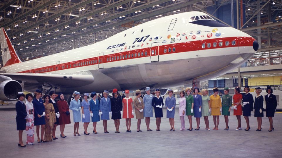The first-ever jumbo jet is rolled out at Boeing's Everett factory, a Boeing 747-100, with cabin crew members of various airline customers in attendance.